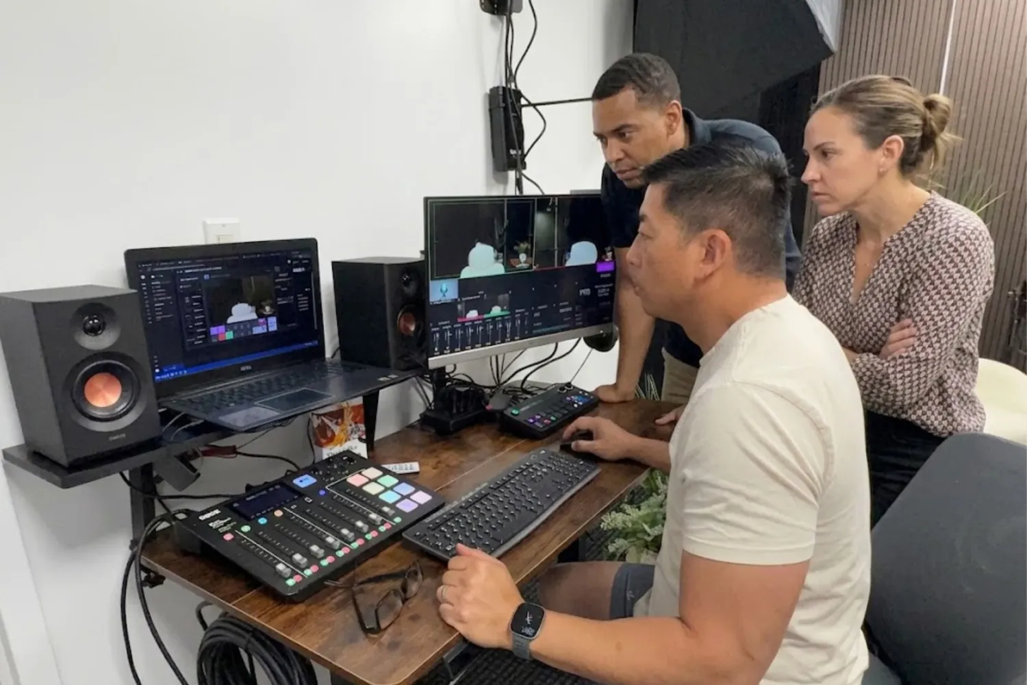 Three people working at a video production desk