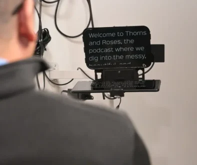 Man reading podcast script from a teleprompter