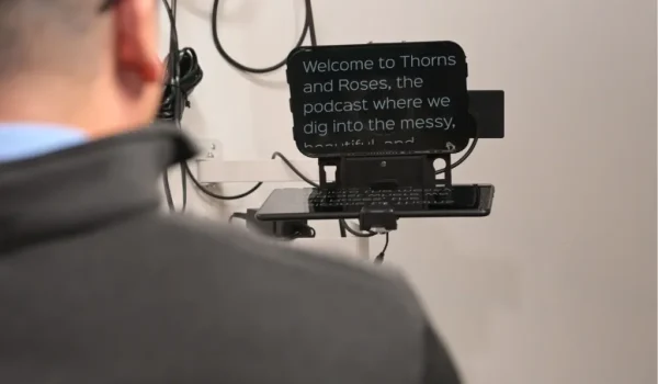 Man reading podcast script from a teleprompter