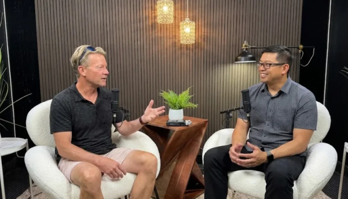 Two men talking into microphones during a podcast